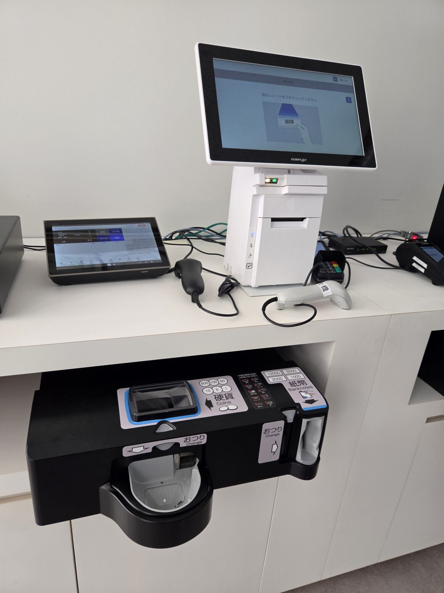 CASHIERのセルフレジ本体とカウンター下に設置された紙幣・硬貨用の自動釣銭機
