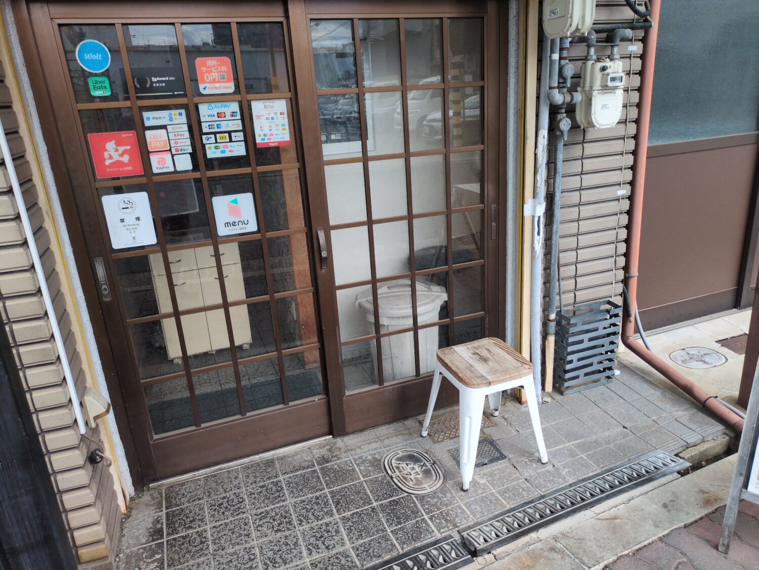 弁当店ぎんのいえの入口に貼られた決済ブランドと出前サービスのシール