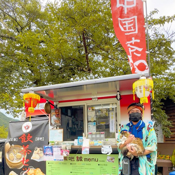 茶吧(TEA BAR)誠のキッチンカー前で猫を抱く店主の五十嵐さん