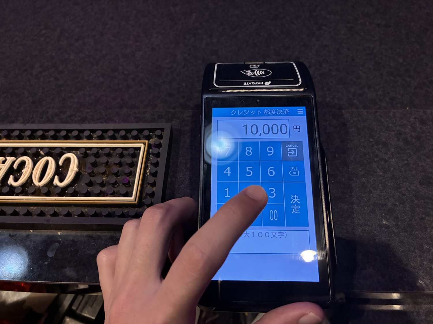 10,000円が表示されたPAYGATEの金額入力画面と数字キーを操作する指
