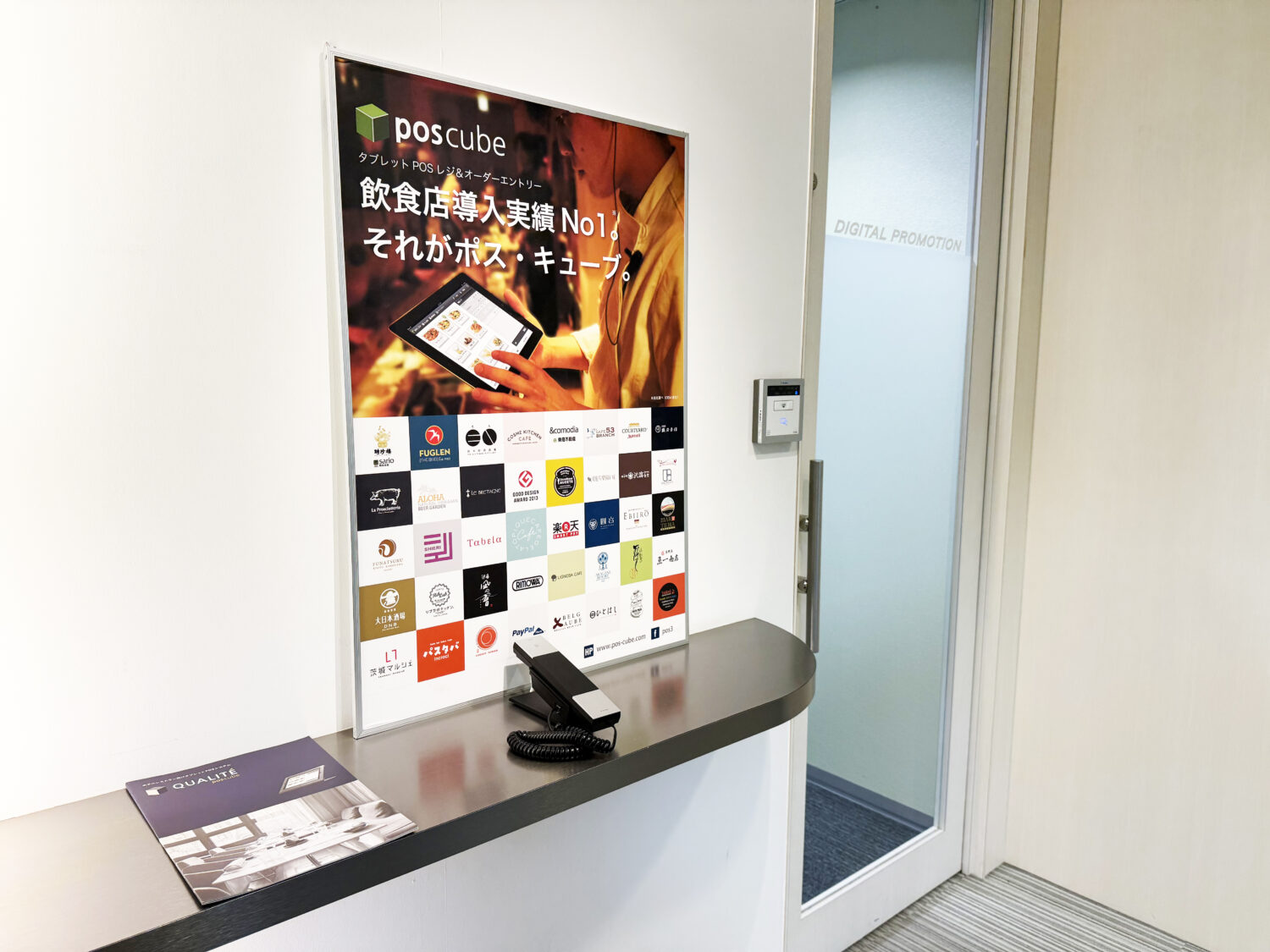 株式会社フォウカスのposcubeショールーム入口に掲示された企業ロゴ