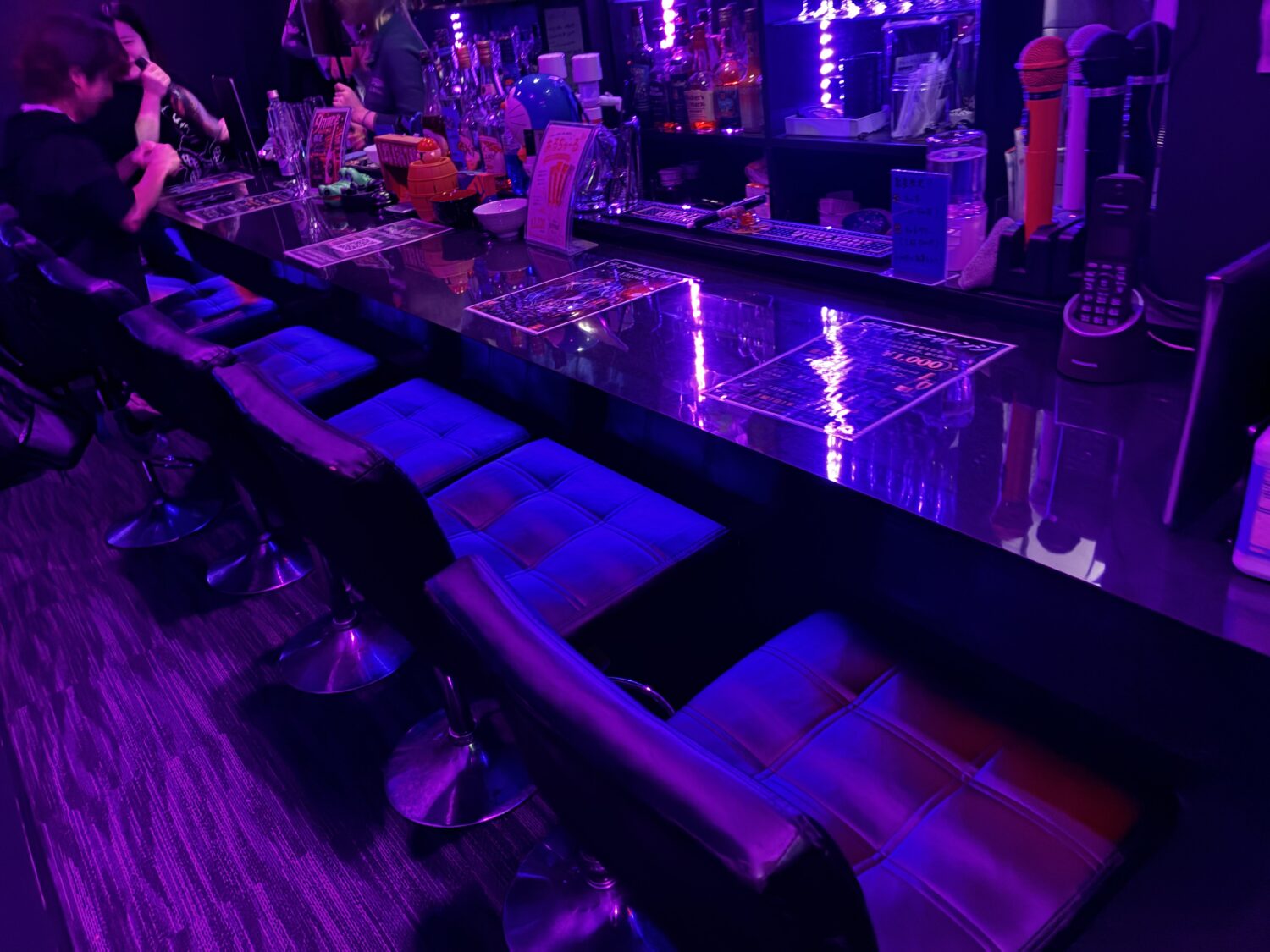BAR STRUのカウンター席と店内に置かれたカラオケ用マイク