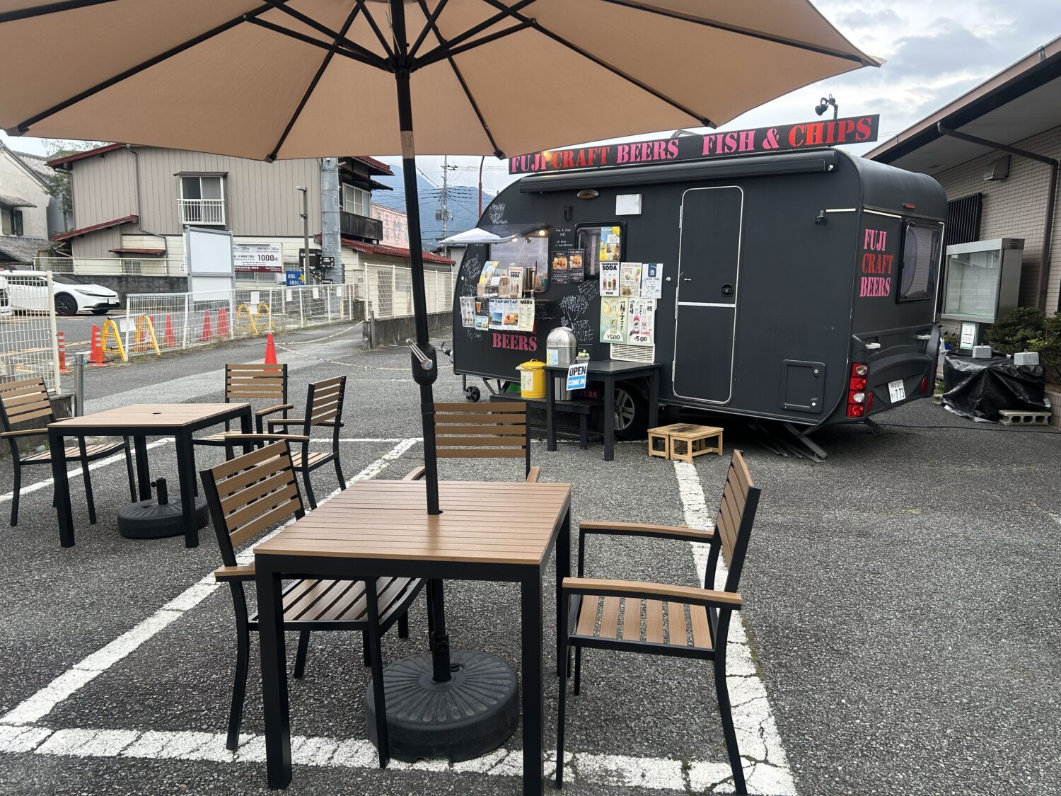 FUJI CRAFT BEERSのキッチンカー前に設置された屋外のテーブルとパラソル