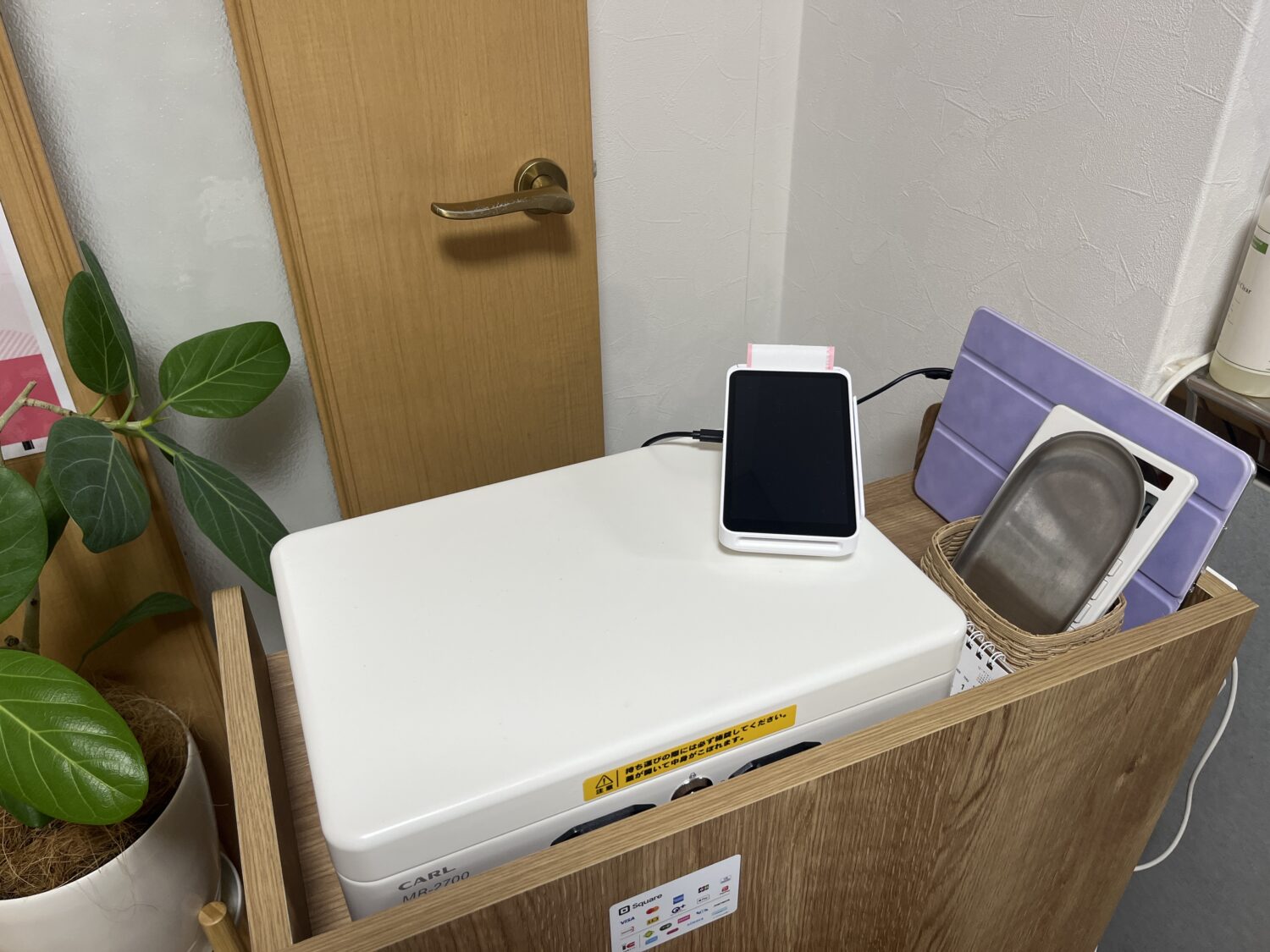 Un Lemieux Laboのレジ台に置かれたSquareターミナルとタブレット、釣銭皿