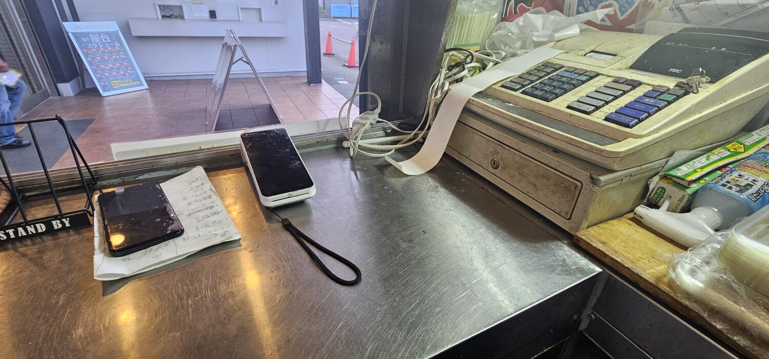 あぶり居酒屋うのっちのキッチンカー内に置かれたPayCAS Mobileとレジスター