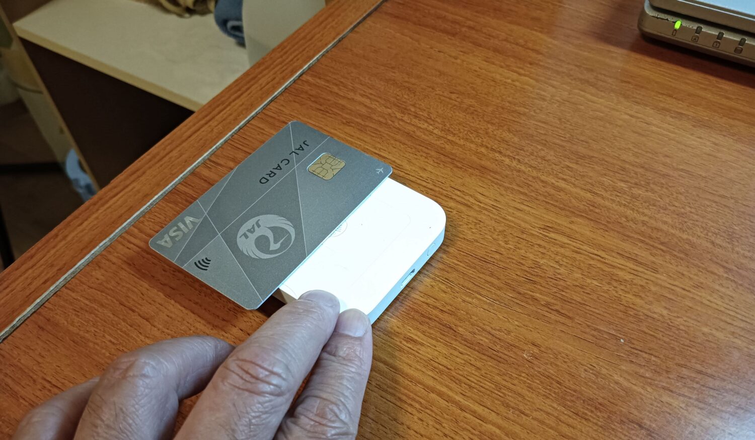 ひろしま頭痛整体院でSquareリーダーにクレジットカードをかざす様子