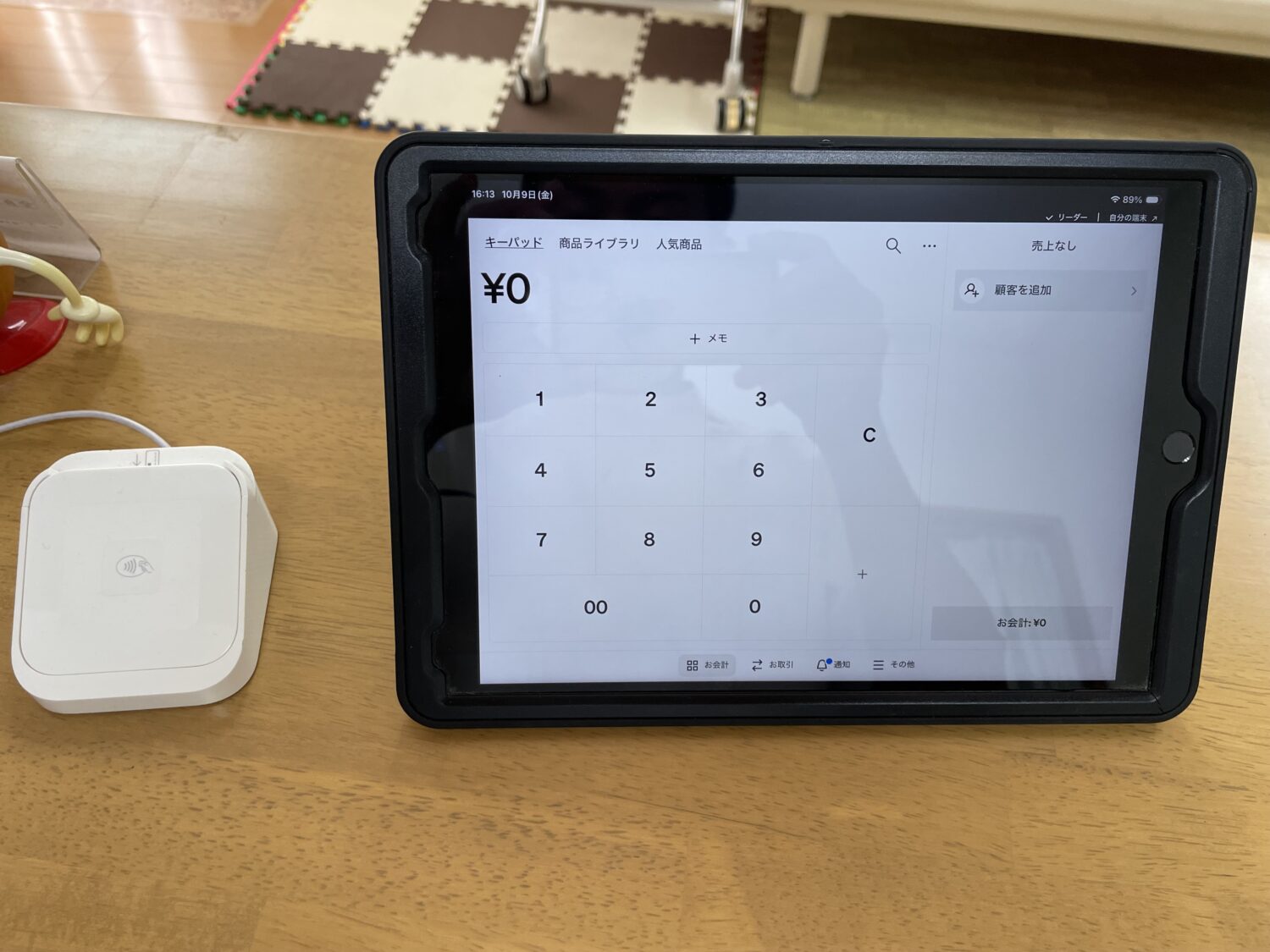 Square POSレジを表示したタブレットとSquareリーダーを並べた会計環境
