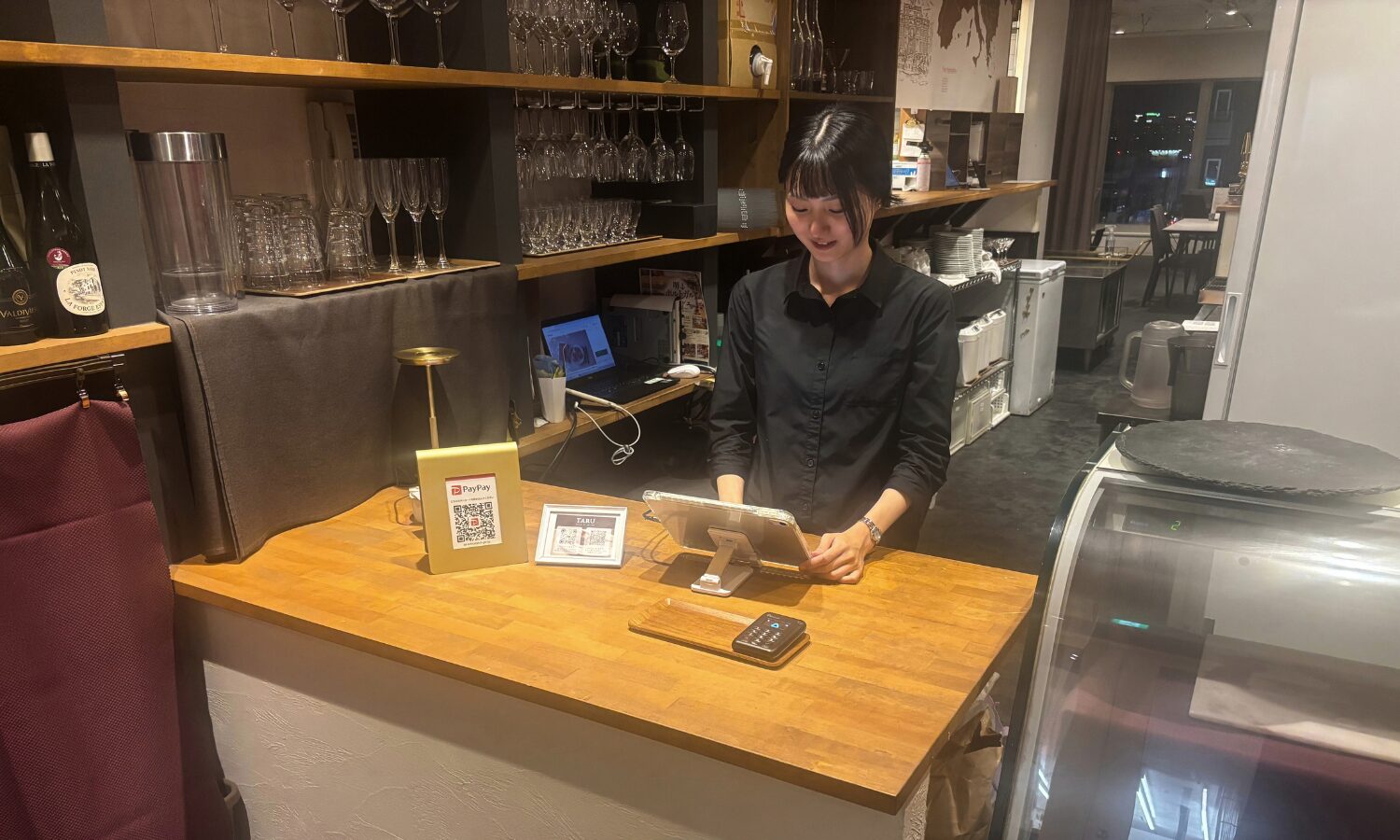 TARU steak&italianのカウンターでiPadを操作するスタッフ