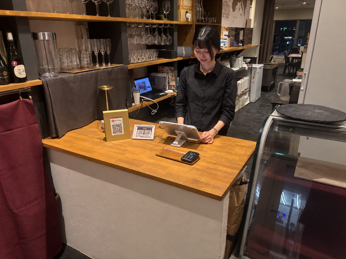 TARU steak&italianのカウンターでiPadを操作するスタッフ