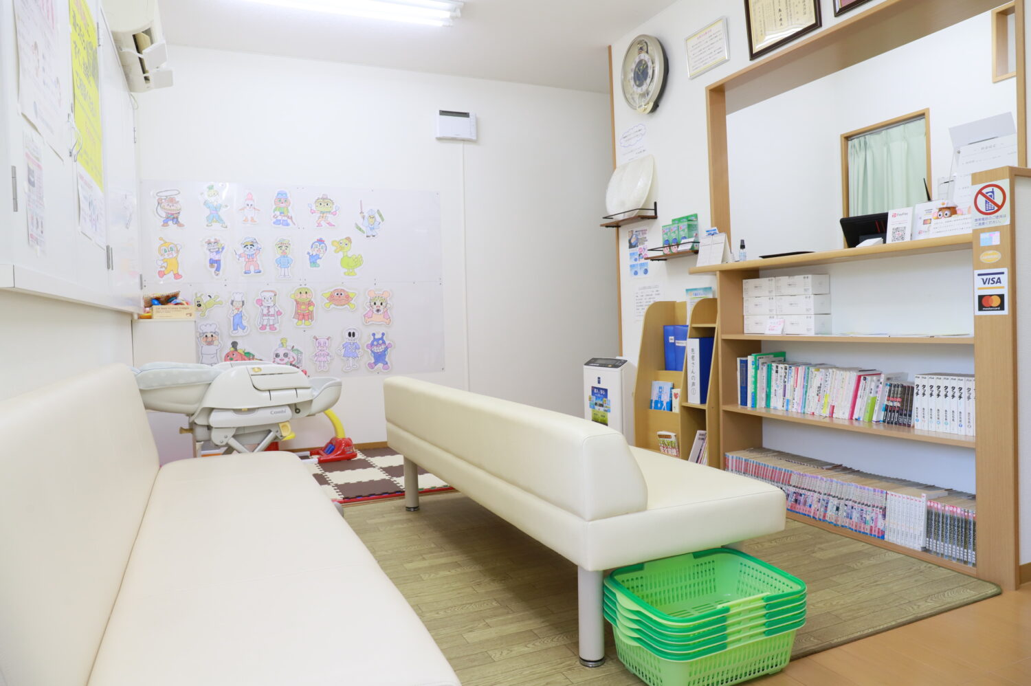中林整骨院・なかもず院のソファや本棚、ベビー用チェアがある待合室