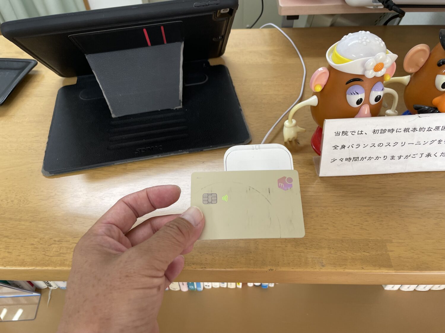 受付のSquareリーダーにタッチ決済対応カードをかざす様子